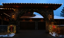 Brick archway of house leading into garage with lit up wreaths